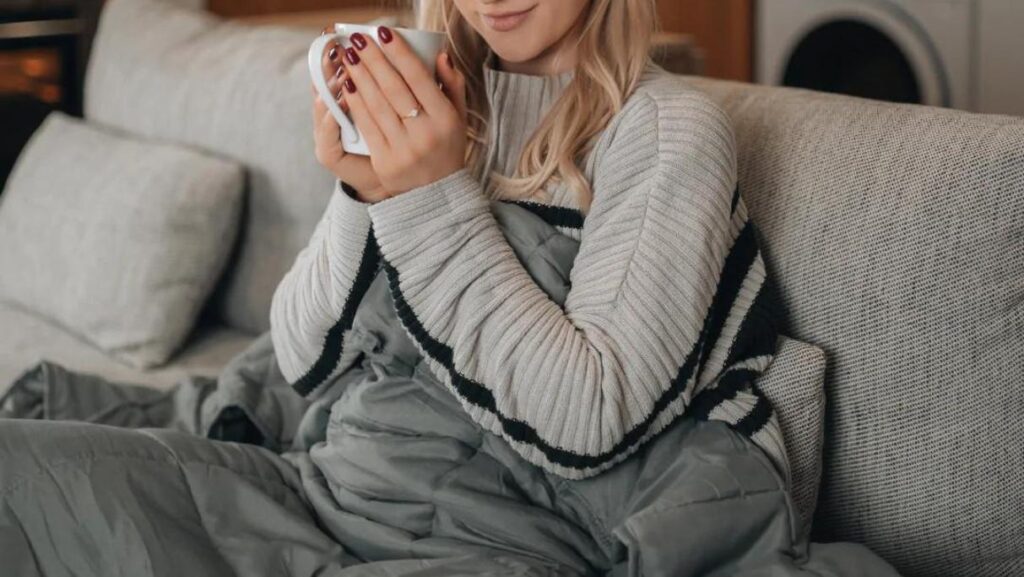 Scandinavian tyngdedyne og kvinde der drikker kaffe i sofa