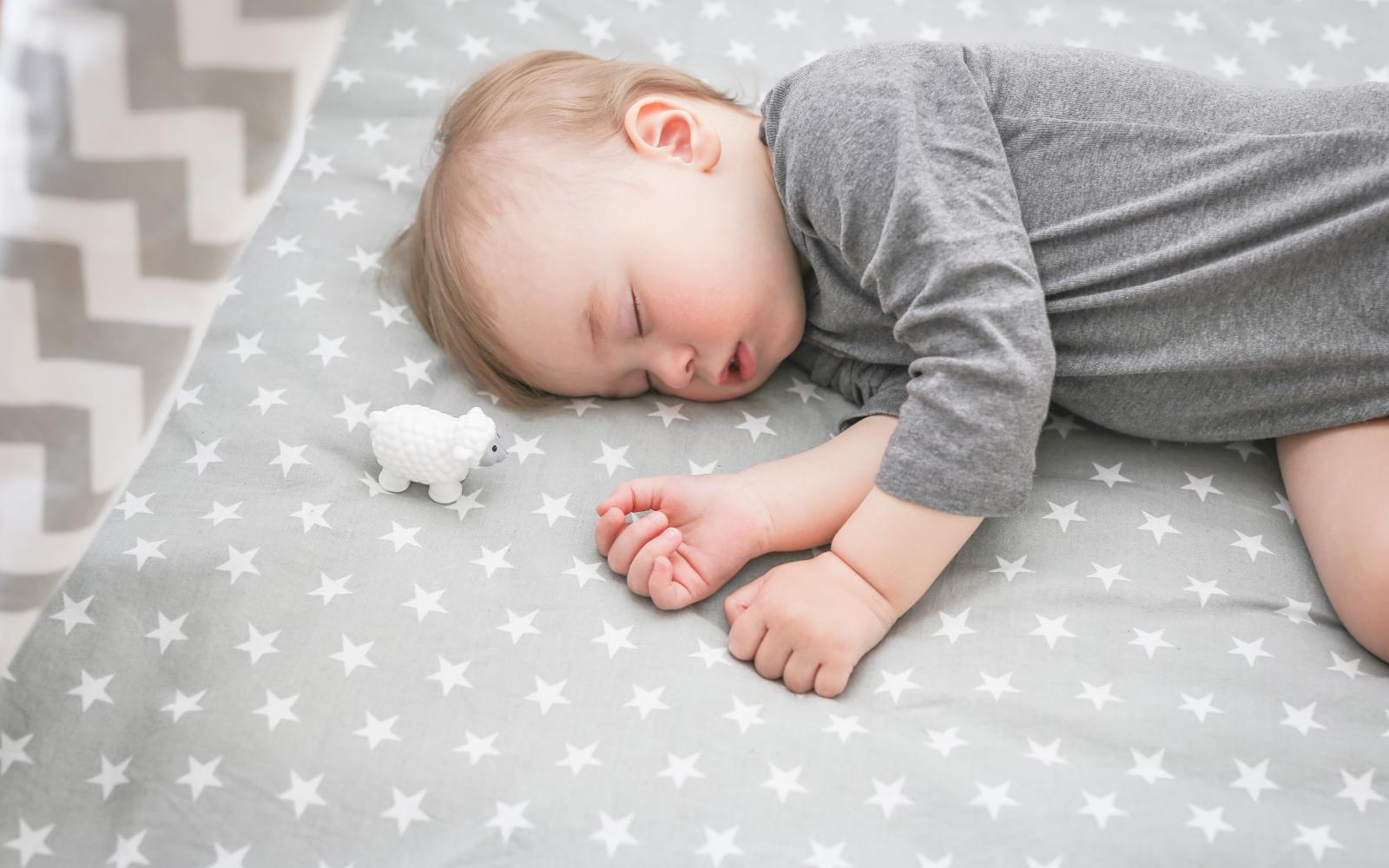 Et billede af et spædbarn som ligger og sover, og måske har brug for en hovedpude