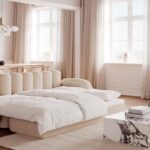 En flot sovesofa i beige som er redt op med dyne og topmadras