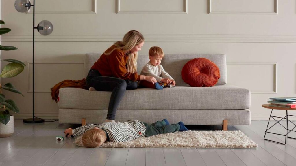 Sigmund Daybed sovesofa i grå med en familie der leger på den