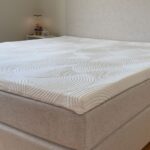 Billede af en topmadras på en beige seng