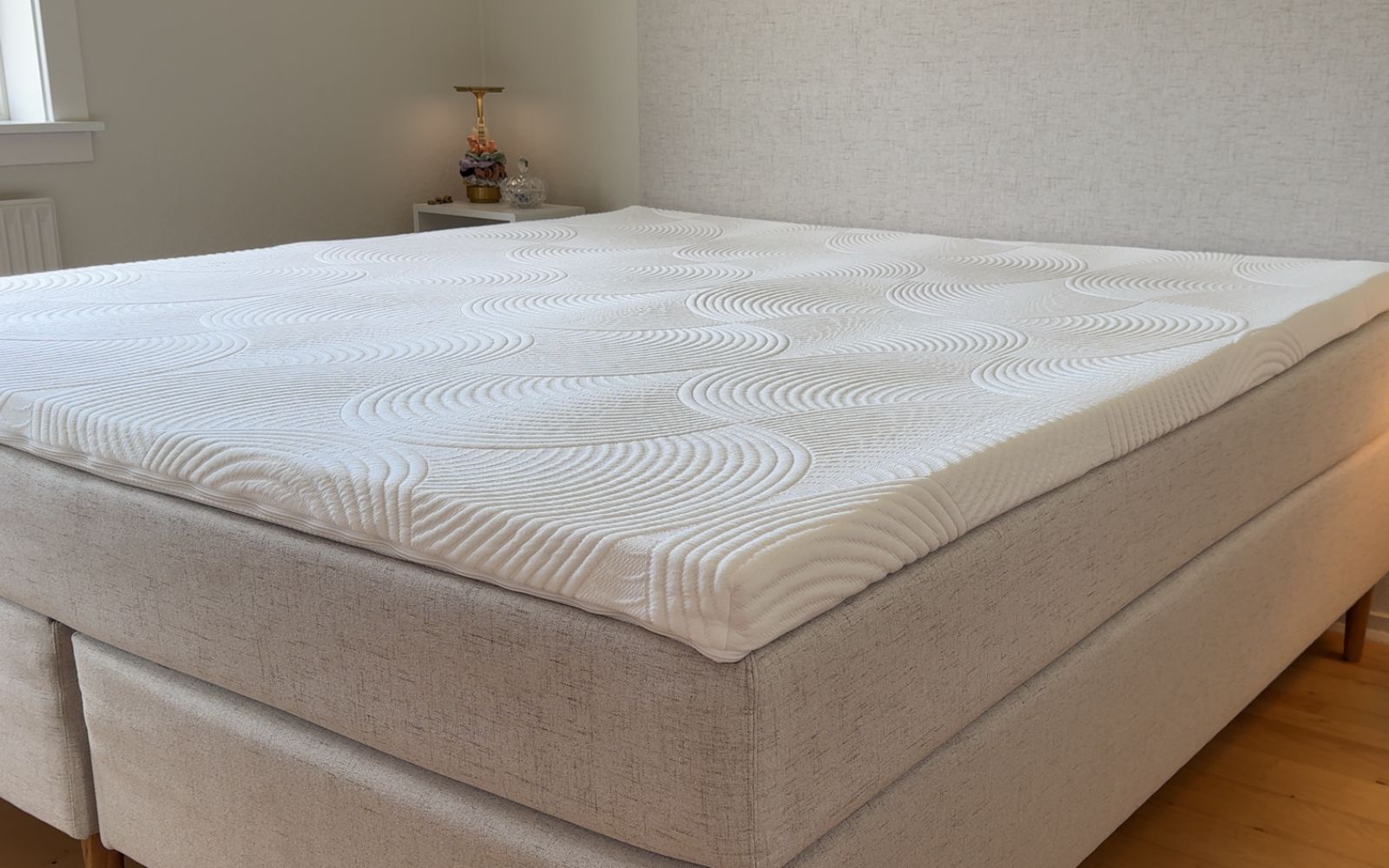 Billede af en topmadras på en beige seng
