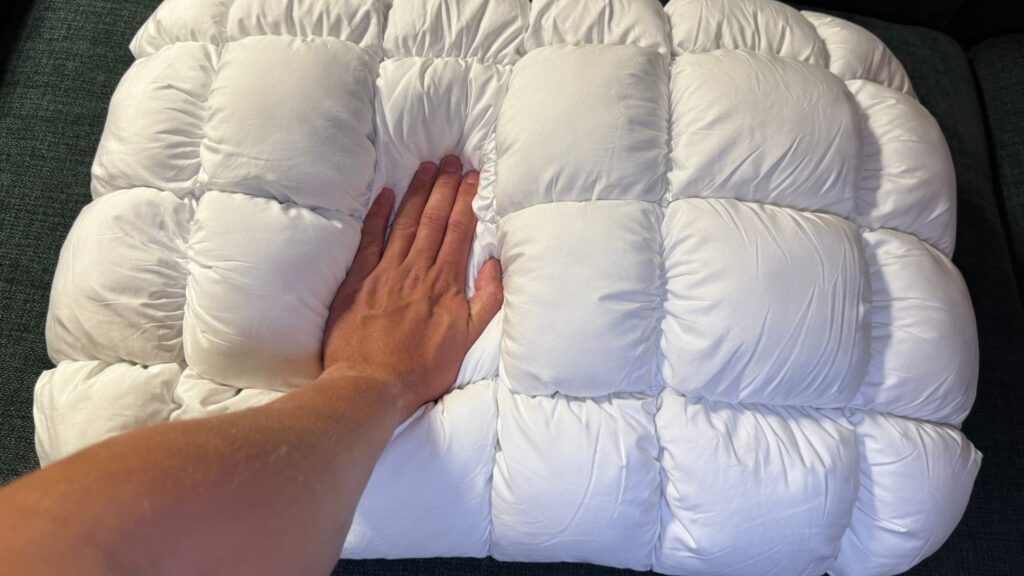 En hånd trykker ned på CloudOne hovedpuden